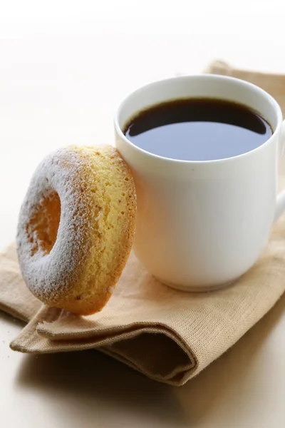 Donut frais saupoudré de sucre en poudre et une tasse de café — Photo
