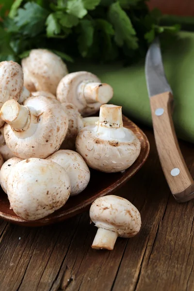 Świeże grzyby champignon na drewnianym stole — Zdjęcie stockowe