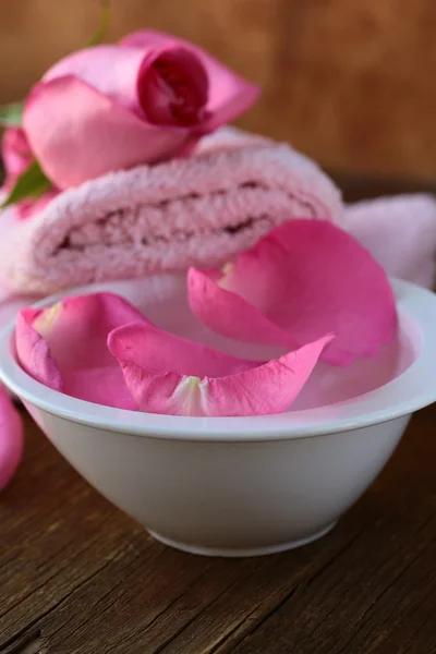 Conceito de spa com pétalas de rosa em um fundo de madeira — Fotografia de Stock