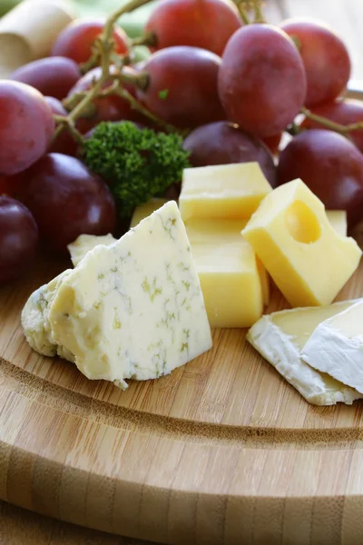 Käseplatte mit drei Käsesorten und Trauben — Stockfoto