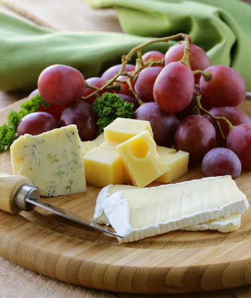 Cheeseboard with three kinds of cheese and grapes — Stock Photo, Image