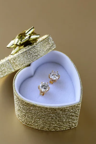 Gold earrings stud with diamonds in a gold box — Stock Photo, Image