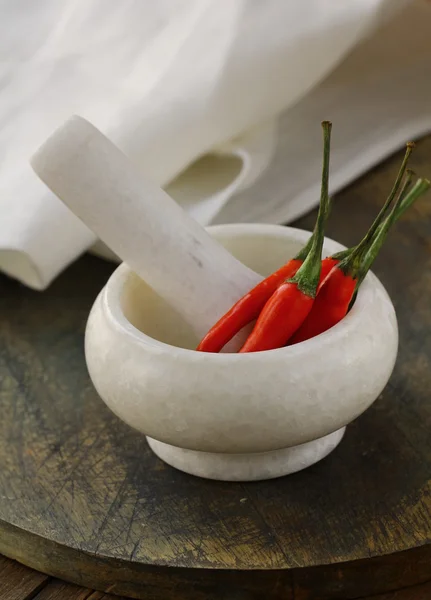 Pimentos de pimenta vermelha em uma argamassa de mármore — Fotografia de Stock