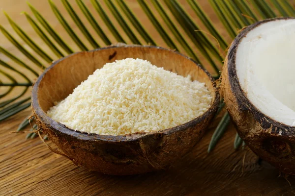 Grounded coconut flakes and fresh coconut — Stock Photo, Image