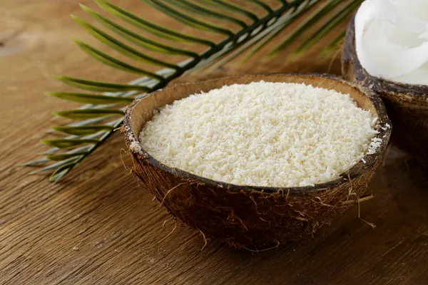 Grounded coconut flakes and fresh coconut — Stock Photo, Image