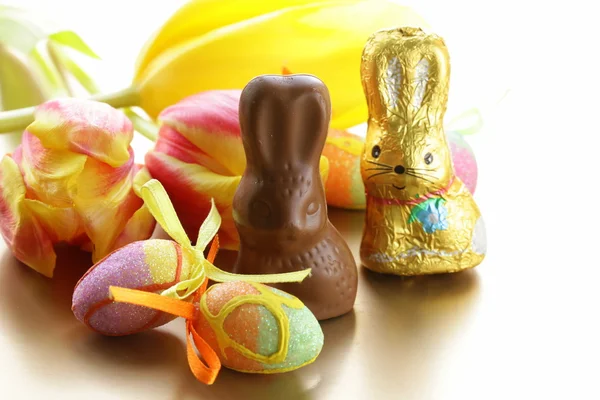 Chocolate Easter bunny (sweets) with tulips — Stock Photo, Image