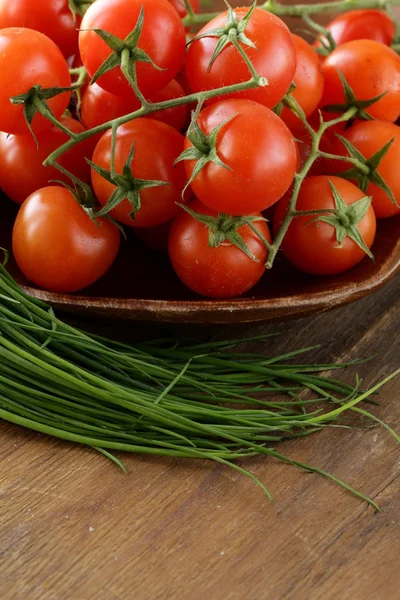 Pomodori ciliegia freschi su piatto di legno — Foto Stock