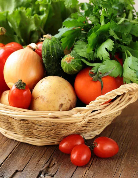 Fresh vegetables and herbs mix in a wicker basket — Stock Photo, Image