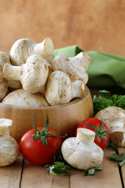 Frische Champignon-Pilze auf einem Holztisch — Stockfoto