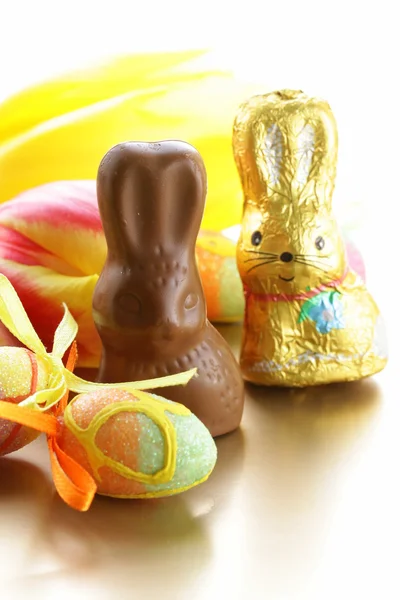 Chocolate Easter bunny (sweets) with tulips — Stock Photo, Image