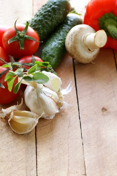 Quadro de verduras (pepino, tomate, cogumelos, alho) em um contexto de madeira — Fotografia de Stock