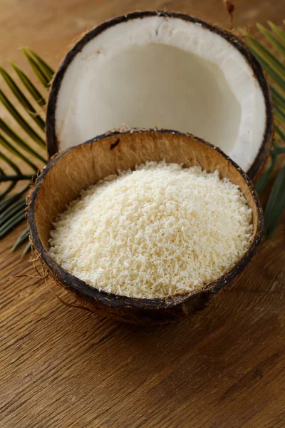 Grounded coconut flakes and fresh coconut — Stock Photo, Image