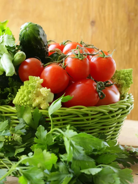 Zöldségfélék (uborka, paradicsom, káposzta romanesco és zöldbab) és a gyógynövények keverjük össze egy fonott kosárban — Stock Fotó