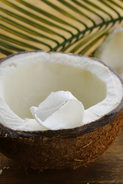 Meio coco fresco em uma mesa de madeira — Fotografia de Stock