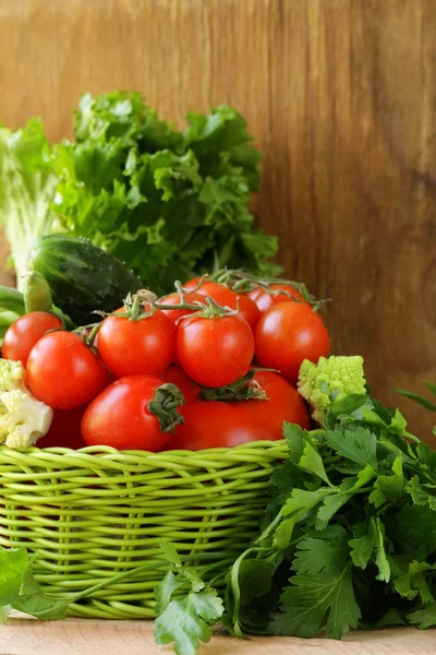 Legumes frescos (pepinos, tomates, repolho romanesco e feijão verde) e ervas se misturam em uma cesta de vime — Fotografia de Stock