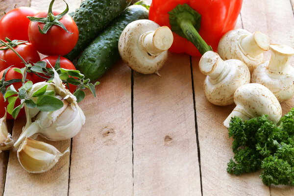 frame of vegetables (cucumber, tomato,mushrooms, garlic) on a wooden background