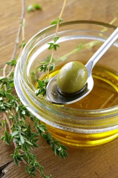 Green marinated olives with oil and thyme — Stock Photo, Image