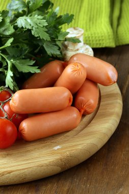 ahşap kesme tahtası üzerine maydanoz ve taze sosis