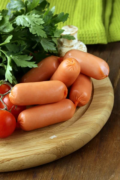 Saucisses fraîches et persil sur planche à découper en bois — Photo