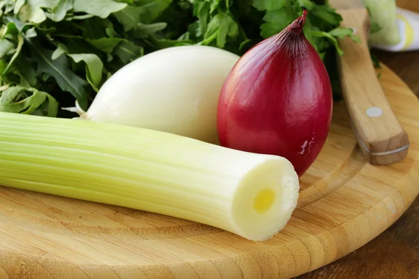 Various types of onions (leeks, red and white) on the cutting board — Stock Photo, Image