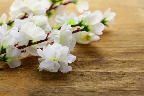 Floração de ramos de árvore sakura (artificial) em um fundo de madeira — Fotografia de Stock