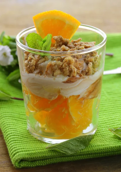 Апельсиновый десерт со сливками и печеньем в стакане — стоковое фото
