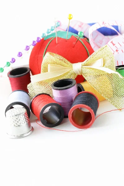 Naaien gebruiksvoorwerpen - spoelen gekleurde draden, pins, vingerhoed Stockfoto