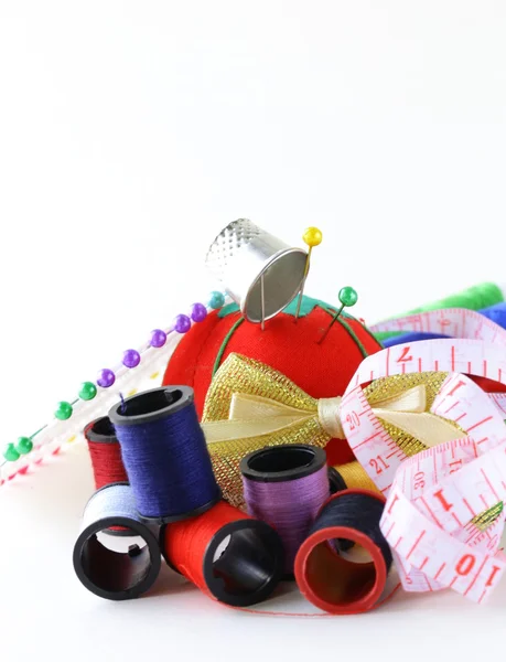 Utensilios de coser - bobinas hilos de colores, alfileres, dedal — Foto de Stock