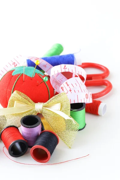 Utensilios de coser - bobinas hilos de colores, alfileres, dedal Fotos de stock