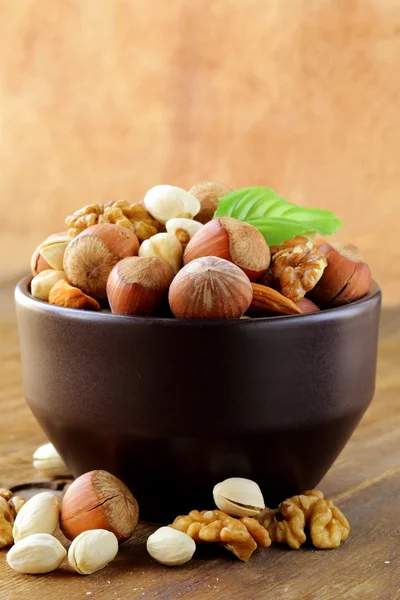 Nüsse mischen - Walnüsse, Haselnüsse, Mandeln auf einem Holztisch — Stockfoto