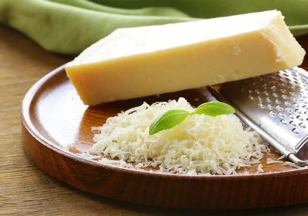 Geriebener Parmesan und Metallreibe auf Holzteller — Stockfoto