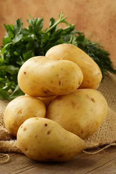 Fresh organic potatoes on a wooden table — Stock Photo, Image