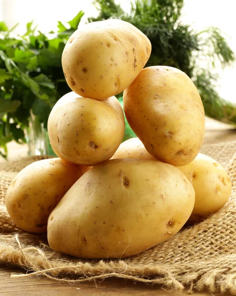 Fresh organic potatoes on a wooden table — Stock Photo, Image