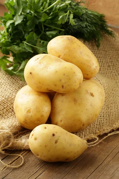 Čerstvé organické brambory na dřevěném stole — Stock fotografie