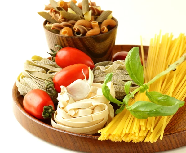 Various types of pasta (spaghetti, fettuccini, penne) and tomato — Stock Photo, Image