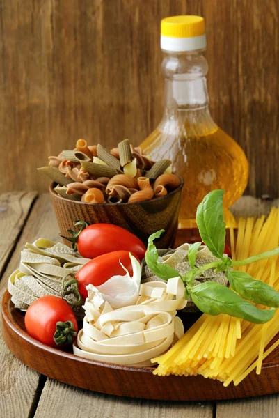 Différents types de pâtes (spaghetti, fettuccini, penne) et de tomates — Photo