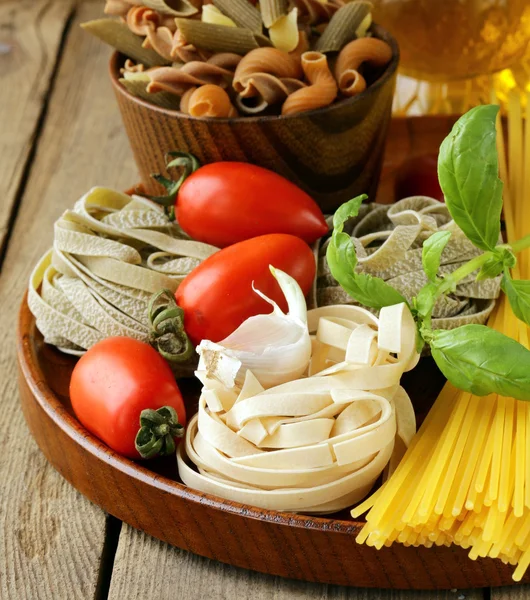Différents types de pâtes (spaghetti, fettuccini, penne) et de tomates — Photo