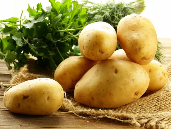 Fresh organic potatoes on a wooden table — Stock Photo, Image