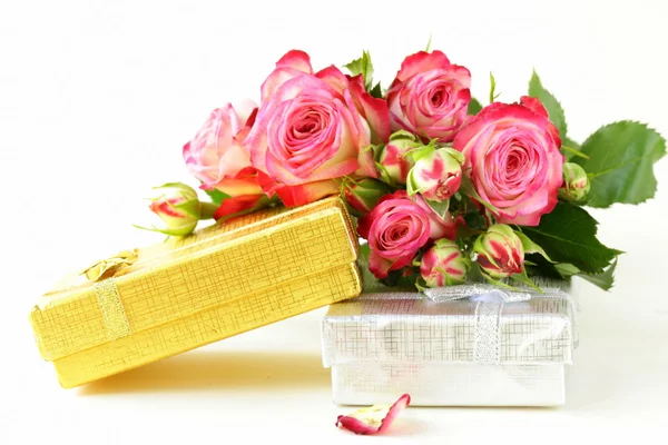 Rosa rosas e caixa com presentes em um fundo branco — Fotografia de Stock