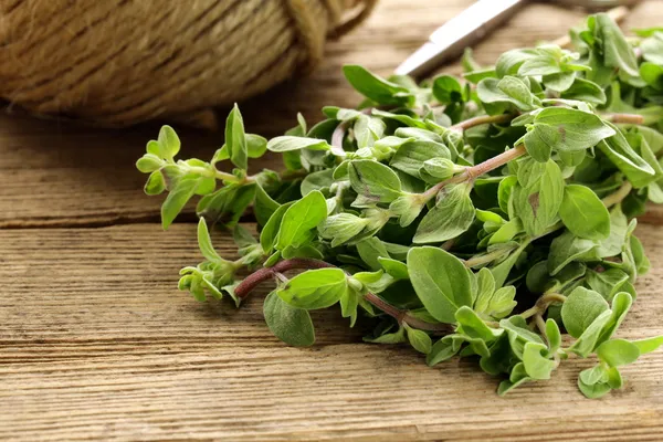 Organické čerstvé oregano (čerstvé majoránky) na dřevěném prkénku — Stock fotografie