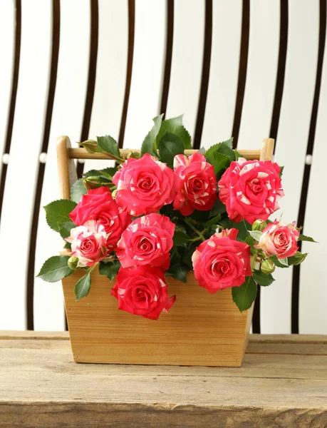 Flores rosas en un jarrón sobre fondo de madera — Foto de Stock