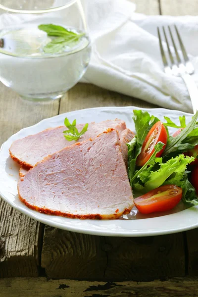 Baked sliced ham served with green salad — Stock Photo, Image