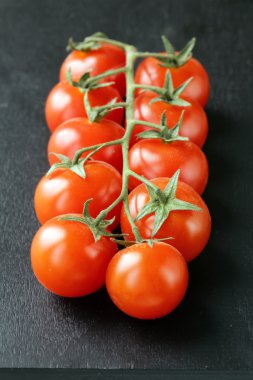 bir dal, siyah zemin üzerine domates