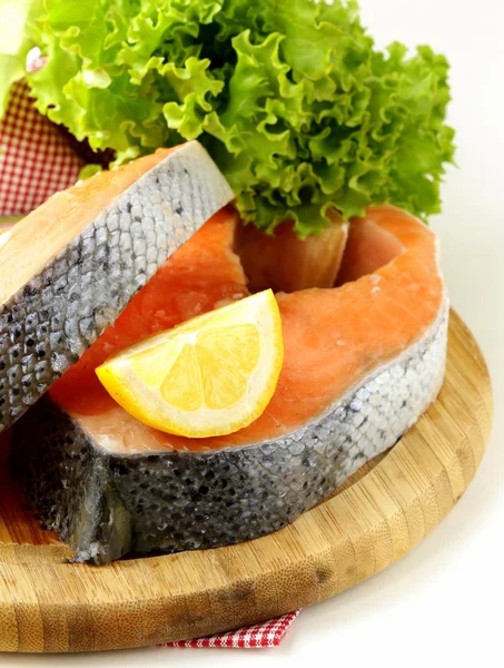 Pescado rojo crudo fresco (salmón) en una tabla de cortar — Foto de Stock