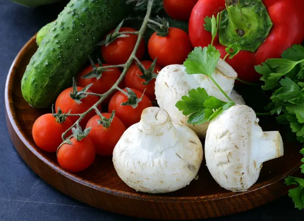 Vida morta de verduras frescas (tomates, cogumelos, pimentas, pepinos) no quadro-negro — Fotografia de Stock