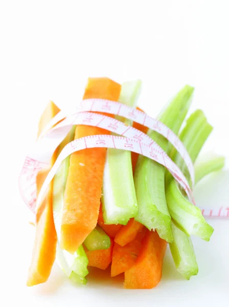 Carrots, green celery, measuring tape on a white background — Stock Photo, Image