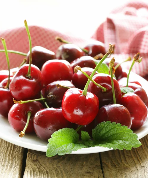 Wiśnia jagody z mięty pozostawia na drewnianym stołem — Zdjęcie stockowe