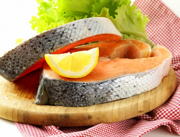 Pescado rojo crudo fresco (salmón) en una tabla de cortar — Foto de Stock