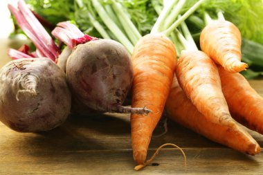 taze organik şeker pancarı ve havuç yaprakları ahşap zemin ile