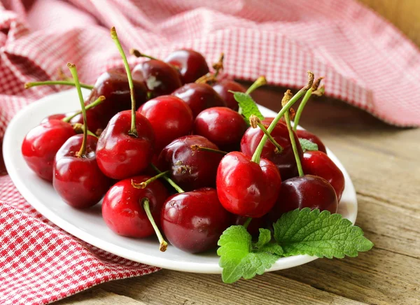 Cherry bessen met munt laat op een houten tafel — Stockfoto